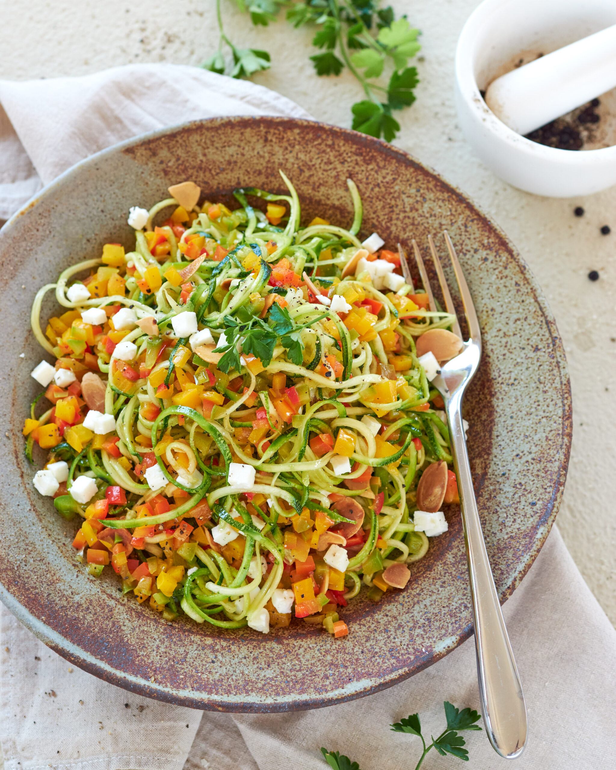 Spaghetti di zucchine con dadolata di peperoni, feta e mandorle tostate